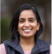 Woman in blue vest smiling at camera